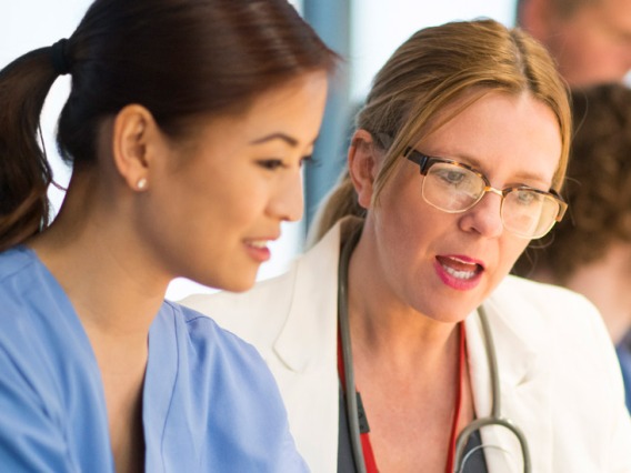 Female doctor speaking to nurse in hospital