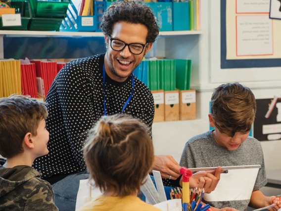 Teacher and young students laughing in classroom