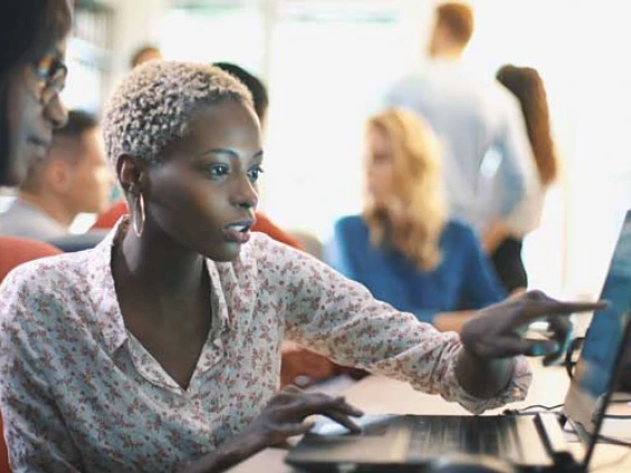 women pointing at laptop