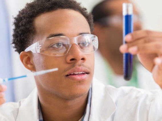 Lab Worker examining contents of vial