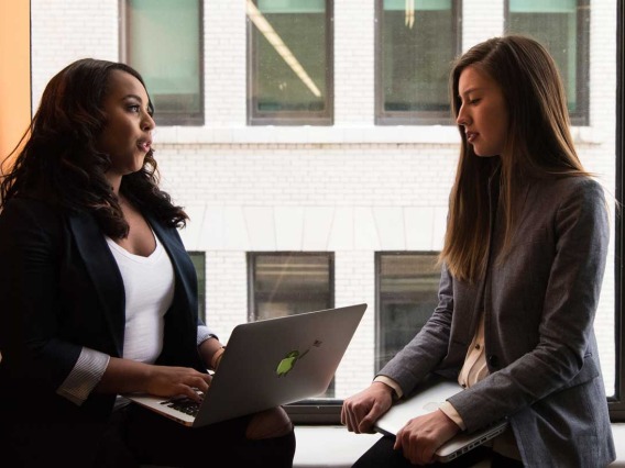 Two women talking over a laptop