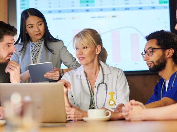 Group of healthcare professionals talking around table