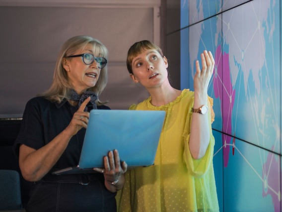 two women looking over data visuals on board