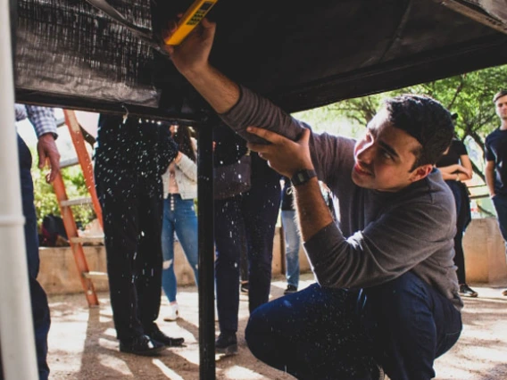 Student measuring underneath a table