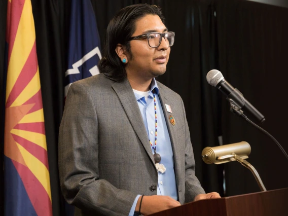 Native American student at podium with microphone