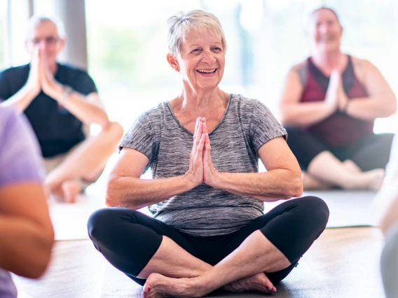 older woman in posing in a yoga class 