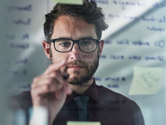 man writing on glass wall