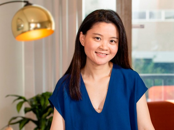 Eller MIS Graduate Binbin Li standing in her living room 