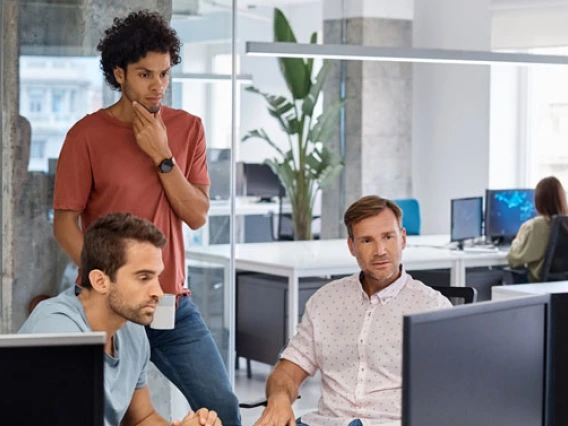 three men looking at a computer screen and thinking