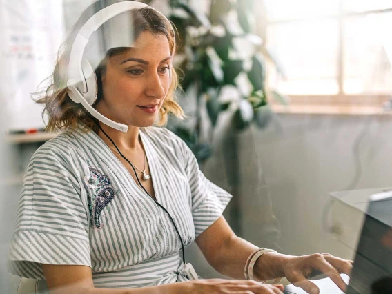 Woman working at a laptop with headphones on