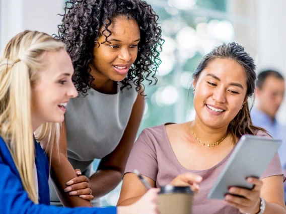 three women looking at tablet