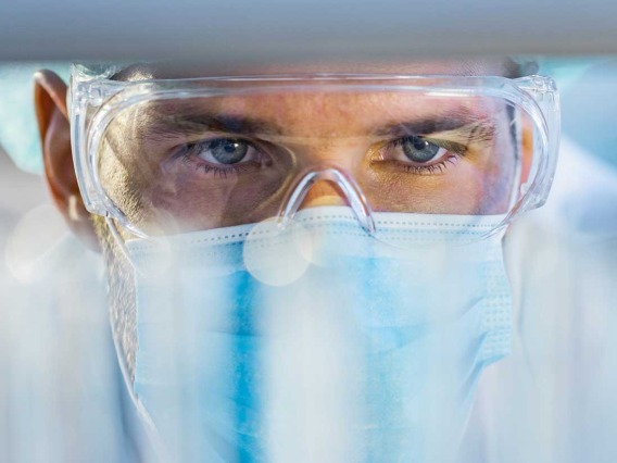 lab technician looking closely at vials 