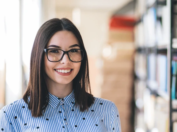 Recent graduate working in library aisles