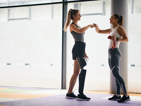 Woman with prosthetic leg working with a trainer 