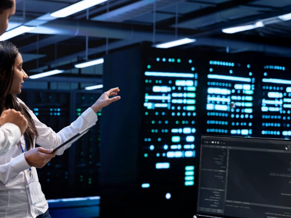 Two professionals standing in a high powered computer and data storage room 