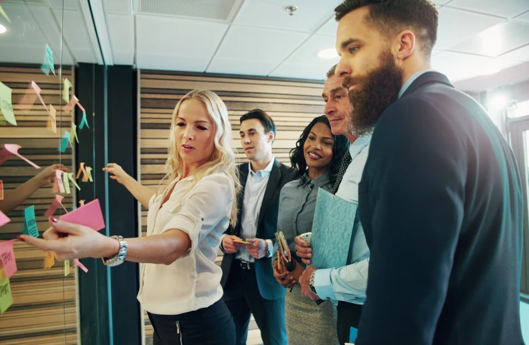 A group of professionals discussing notes on a board. 
