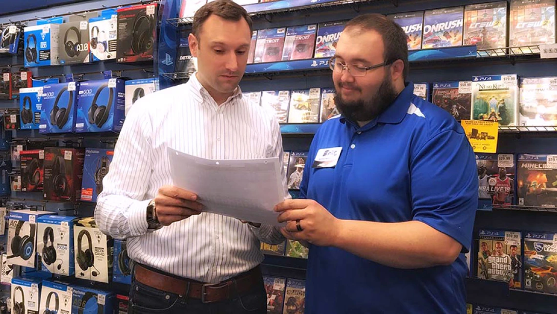 Dash Singleton speaking with employees at a GameStop store.