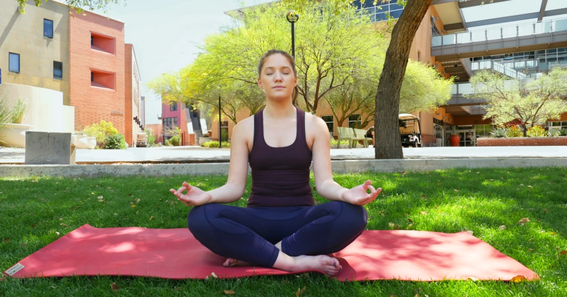 Photograph of a student meditating outdoors