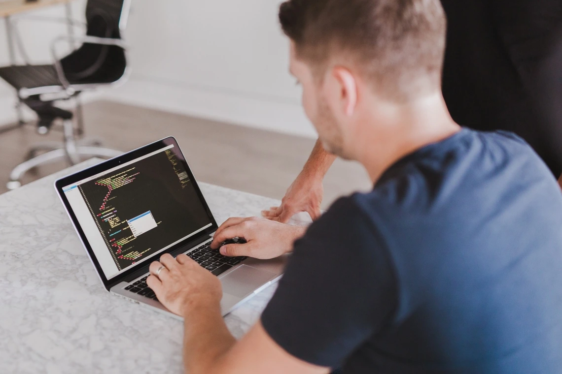 man typing on laptop