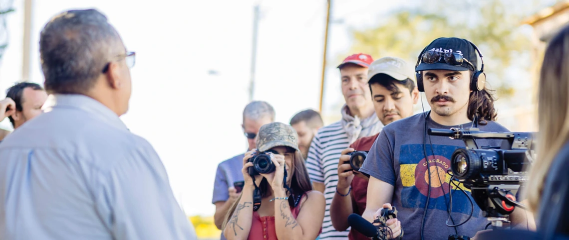 Bilingual journalists interviewing a man on the street in Nogales, Mexico