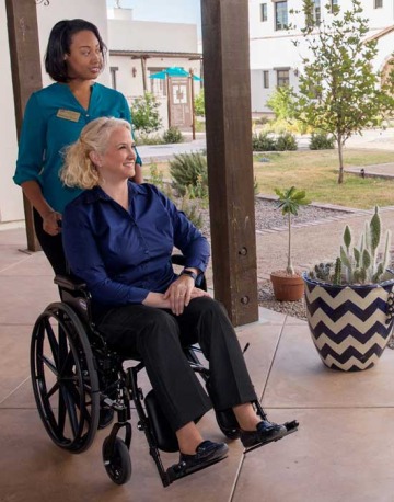 Nurse helping woman in wheelchair