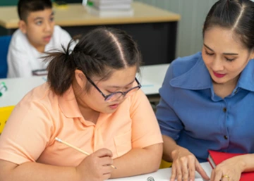 Teacher working with student in classroom