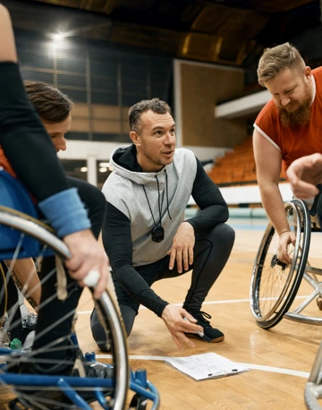 Coach of wheelchair basketball discusses game strategy with players