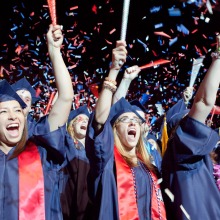 graduate students in caps and gowns celebrating