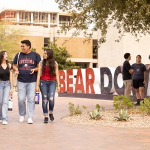 students walking by bear down sign