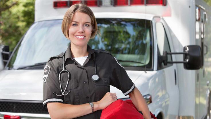 Emergency Medical Technician standing outside ambulance  