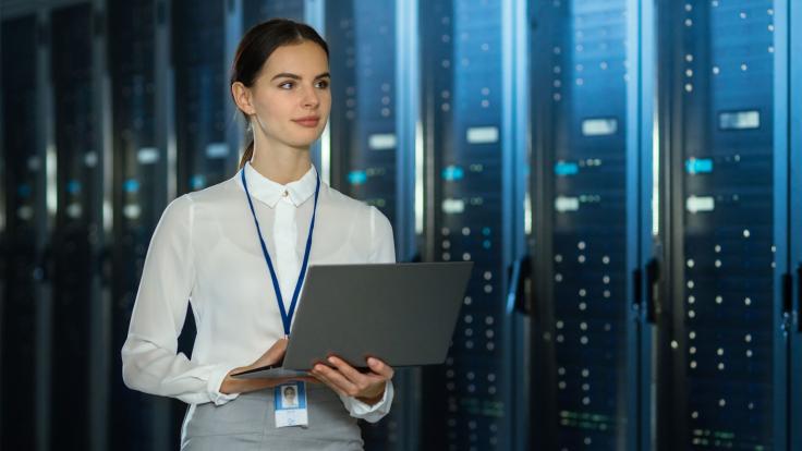 Woman in a database room with laptop