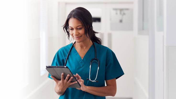 female nurse looking over a tablet