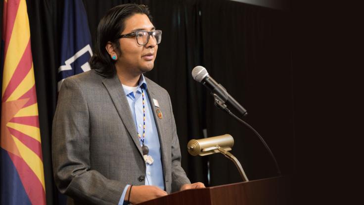 Native American student at podium with microphone