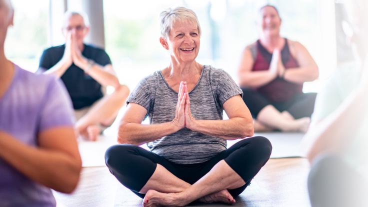 older woman in posing in a yoga class 