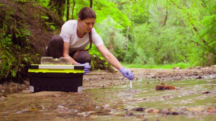 Scientist taking water samples from a river 