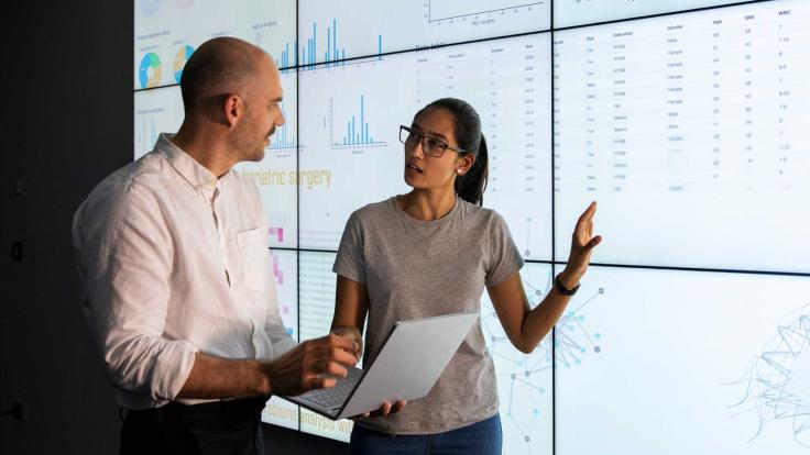 Man and woman discussing Data on a screen