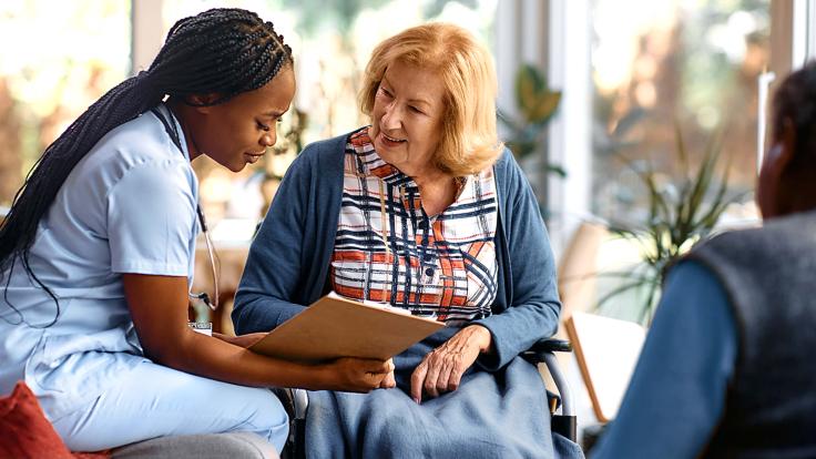 Nursing healthcare professional helping elderly patient