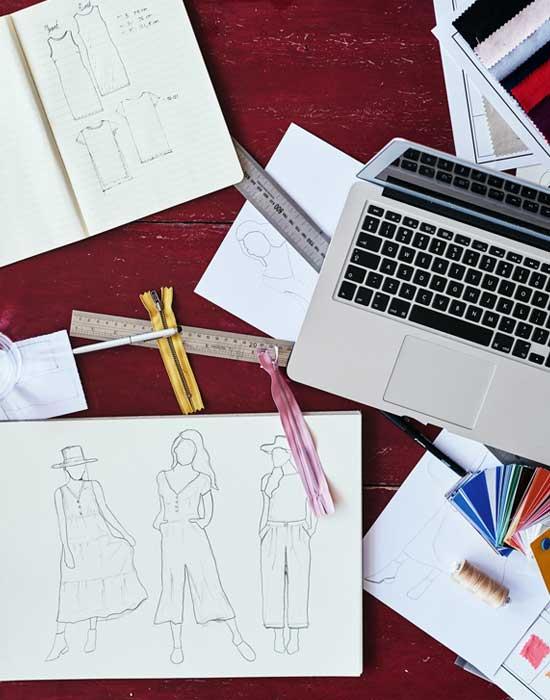 desk with fashion illustrations and computer