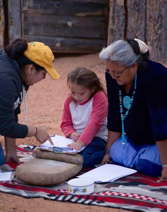 Director explaining script to Navajo child while Grandmother looks on