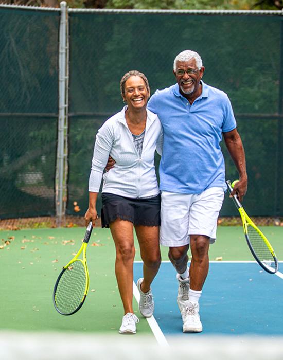 active older aged couple finishing a game of tennis 