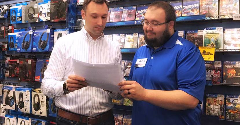 Dash Singleton speaking with employees at a GameStop store.