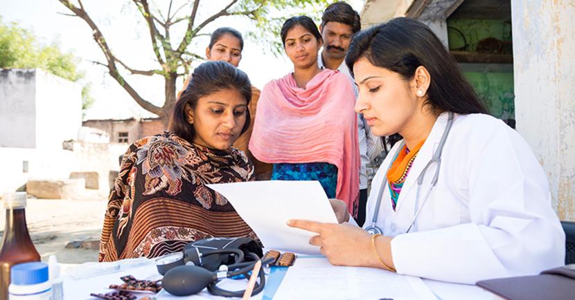 Doctor performing checkups with a female patient and her family in India 