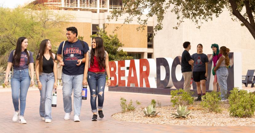 students walking by bear down sign
