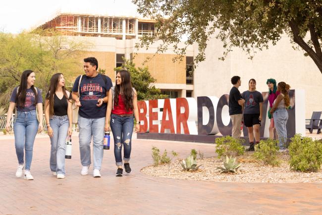 students walking by bear down sign